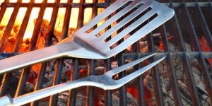 Empty Hot Flaming Charcoal Grill With BBQ Tools. Summer Outdoor Party Or Picnic Concept